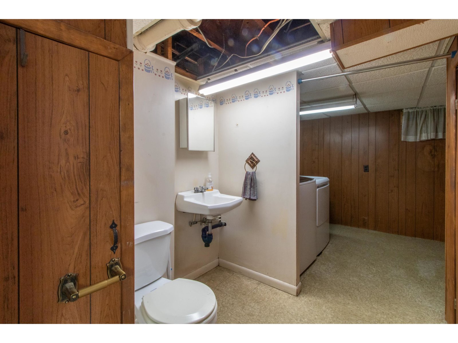 Basement half bathroom with washer and dryer