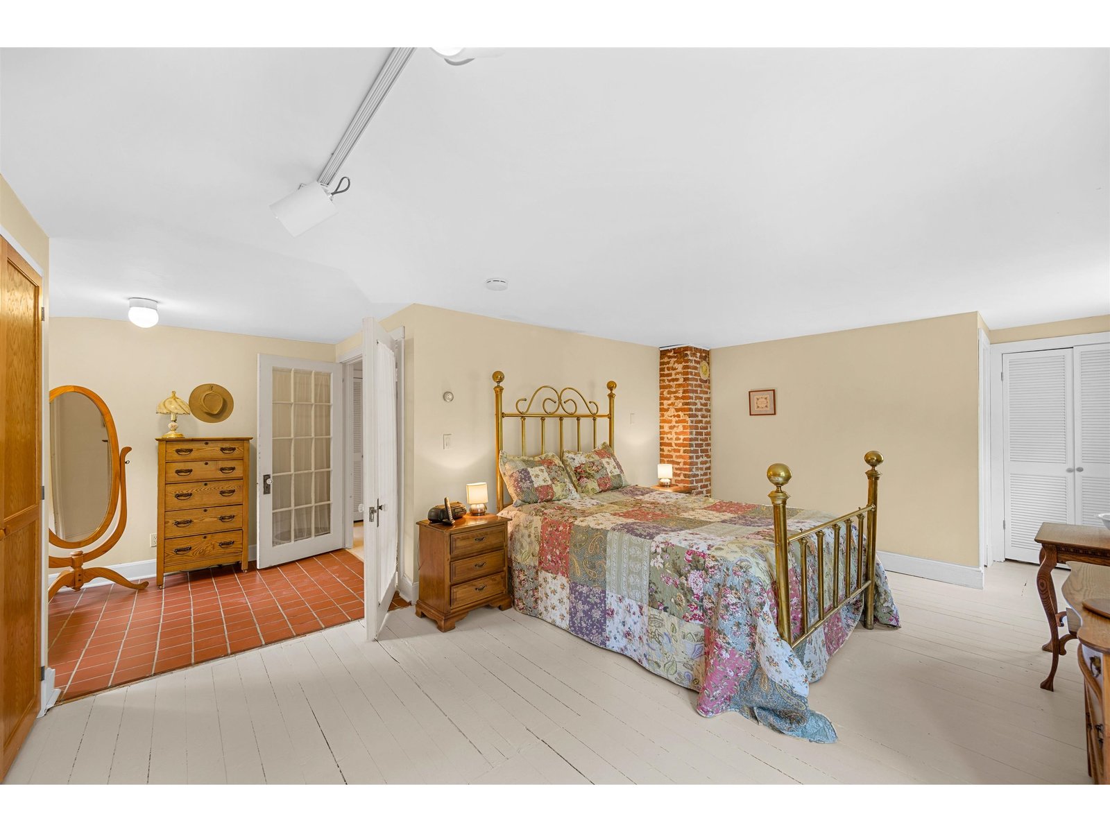 Primary suite with foyer, bathroom, built-ins, and a closet