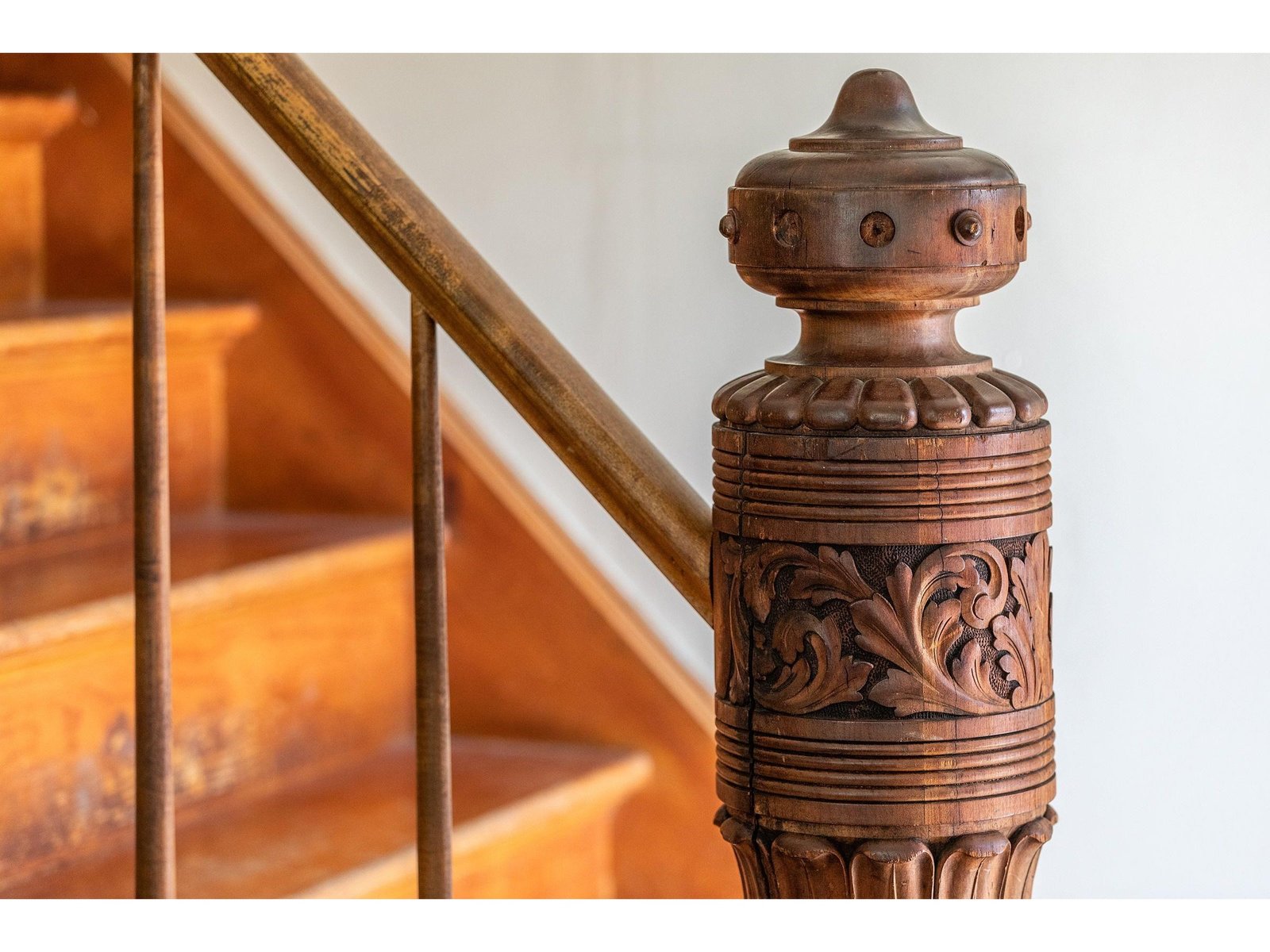 The post detail is exquisite as the stairs lead to the second floor of this 1945 cape style home.