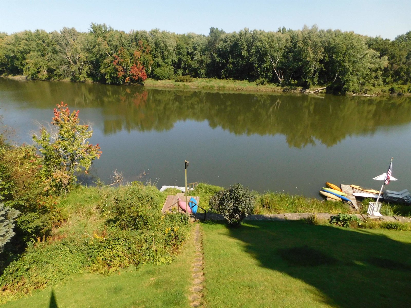 Perspective shows the yard and walkway declining to the shoreline.